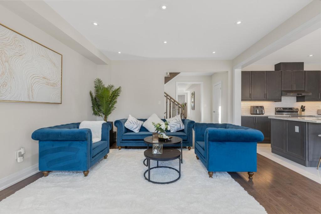 a living room with blue couches and a table at Executive 5BR-4BATH Detached Bramp/Miss Border in Brampton