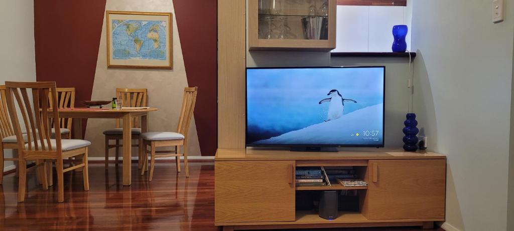 a living room with a television on a wooden entertainment center at Northbridge Pearl in Perth