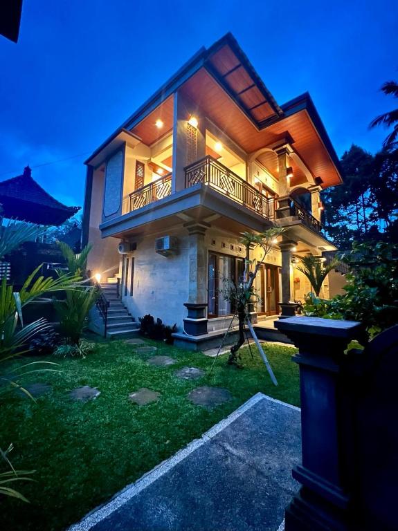 una casa con balcón por la noche en Rare House en Ubud