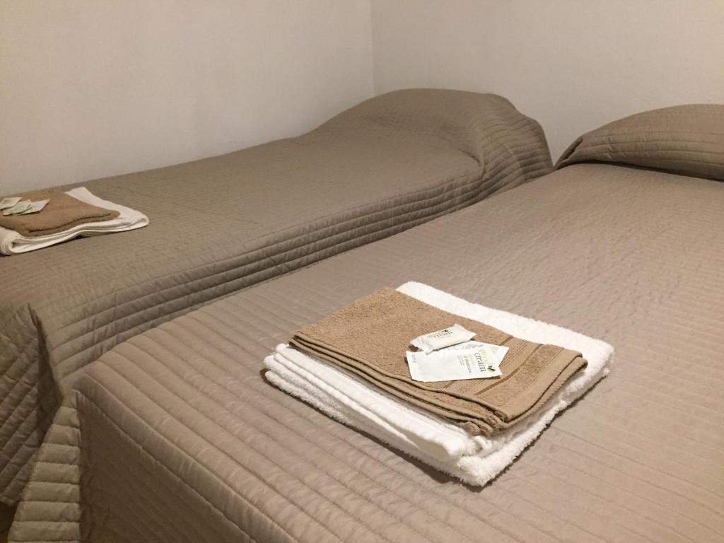 two beds with towels sitting on top of them at Piedrabuena Yenua in Comandante Luis Piedra Buena