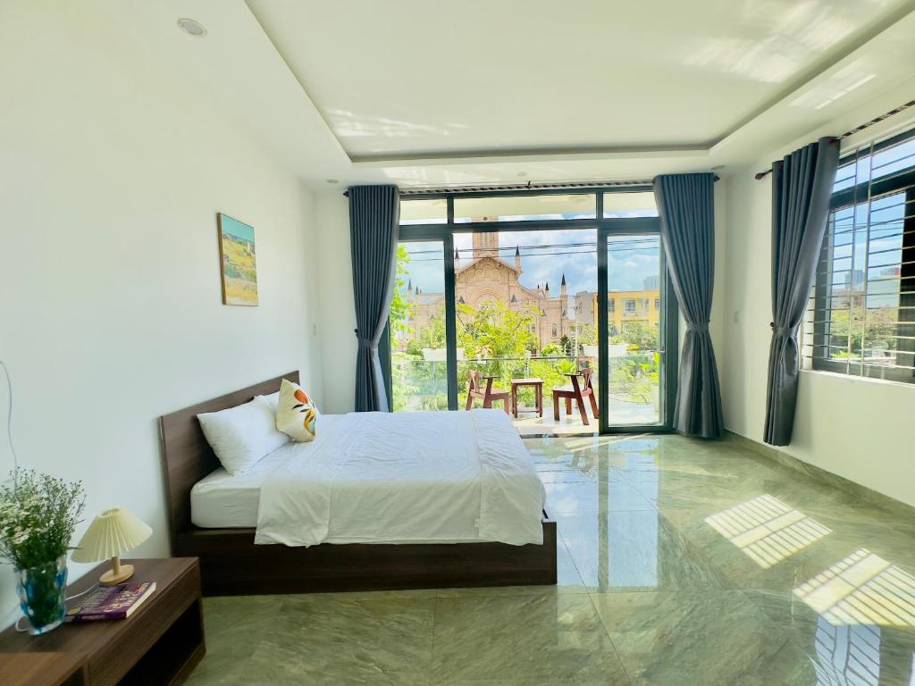 a bedroom with a bed and a large window at The Hygge House in Da Nang