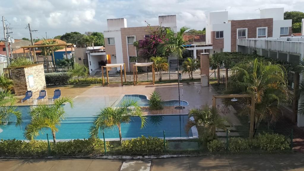 - une vue sur une piscine bordée d'arbres et de bâtiments dans l'établissement Casa Bela Praia, à Marechal Deodoro