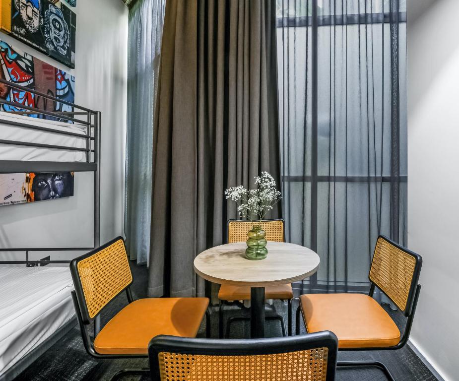 a room with a table and chairs and a bed at The Urban Newtown in Sydney