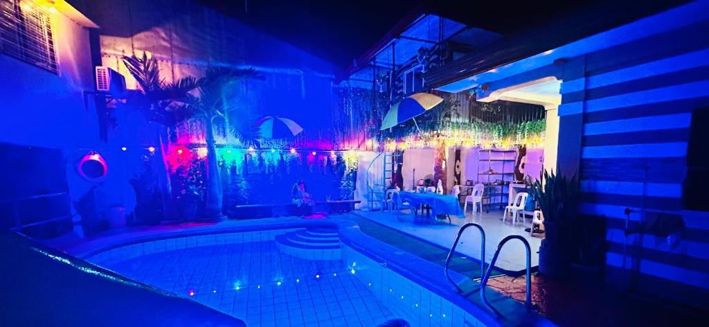 a swimming pool in a building with colorful lights at Cozy room with outdoor swimming pool in Olongapo