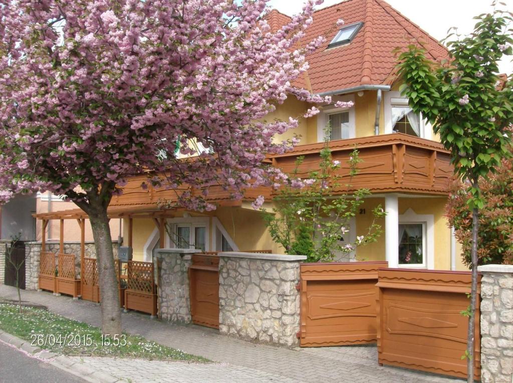 una casa con un árbol floreciente delante de ella en Zsuzsanna Ház, en Hévíz