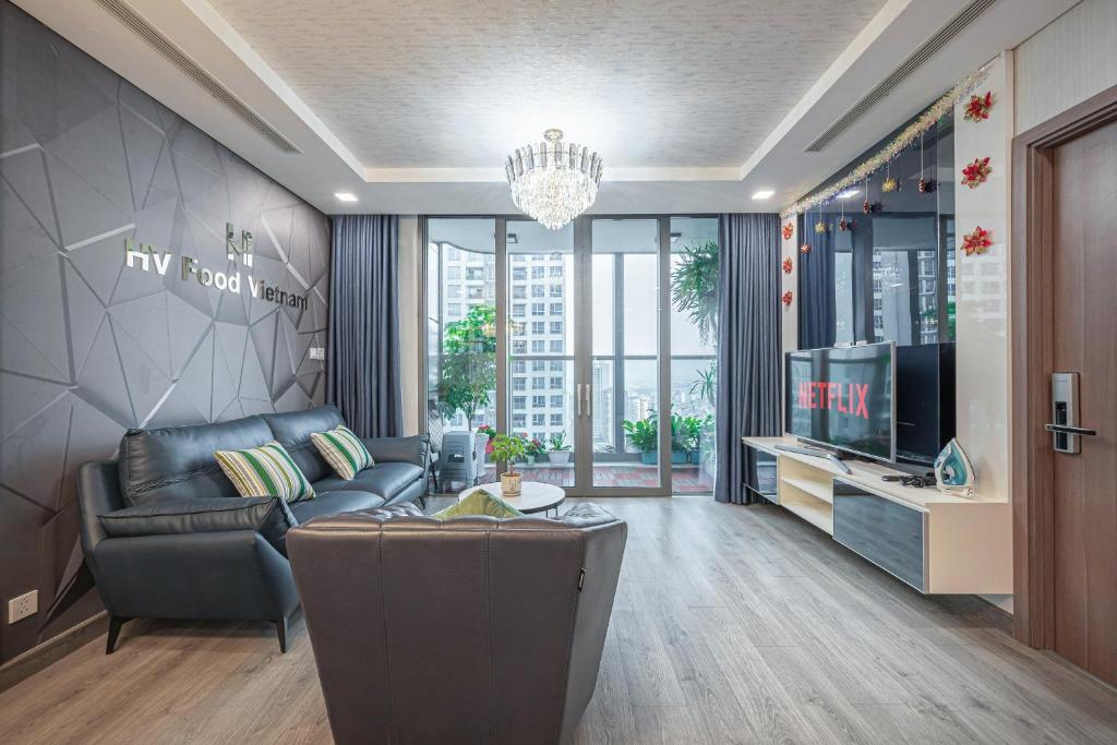 ein Wohnzimmer mit einem Sofa und einem TV in der Unterkunft LANMARK 81 Enigma Residences in Ho-Chi-Minh-Stadt