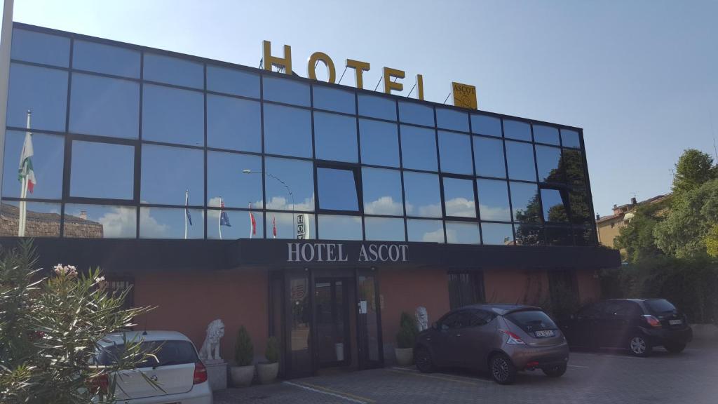 a hotel with cars parked in front of a building at Hotel Ascot in Binasco