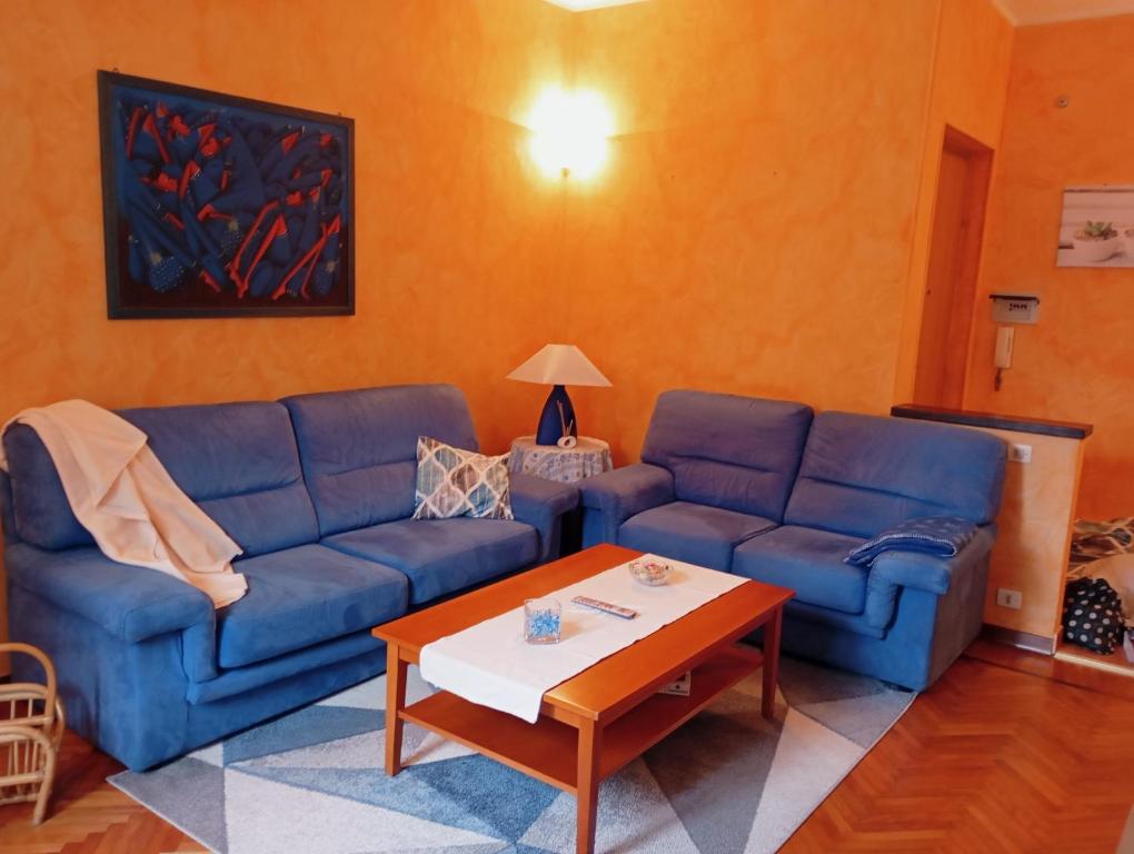 salon z niebieskimi kanapami i stolikiem kawowym w obiekcie A casa di Fabio w mieście Biella