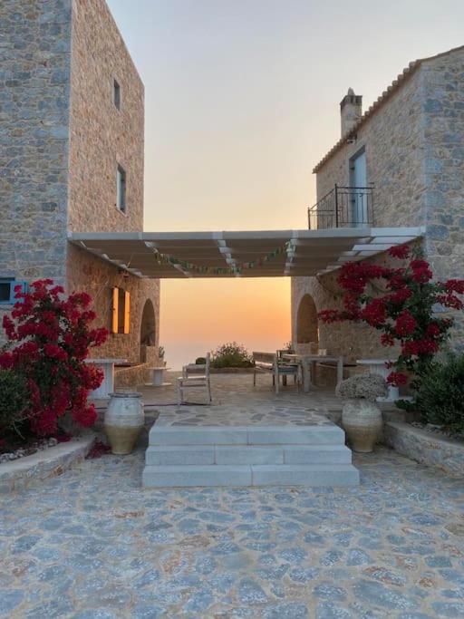 a patio with a table and a patio umbrella at Elemani Villas in Areopoli