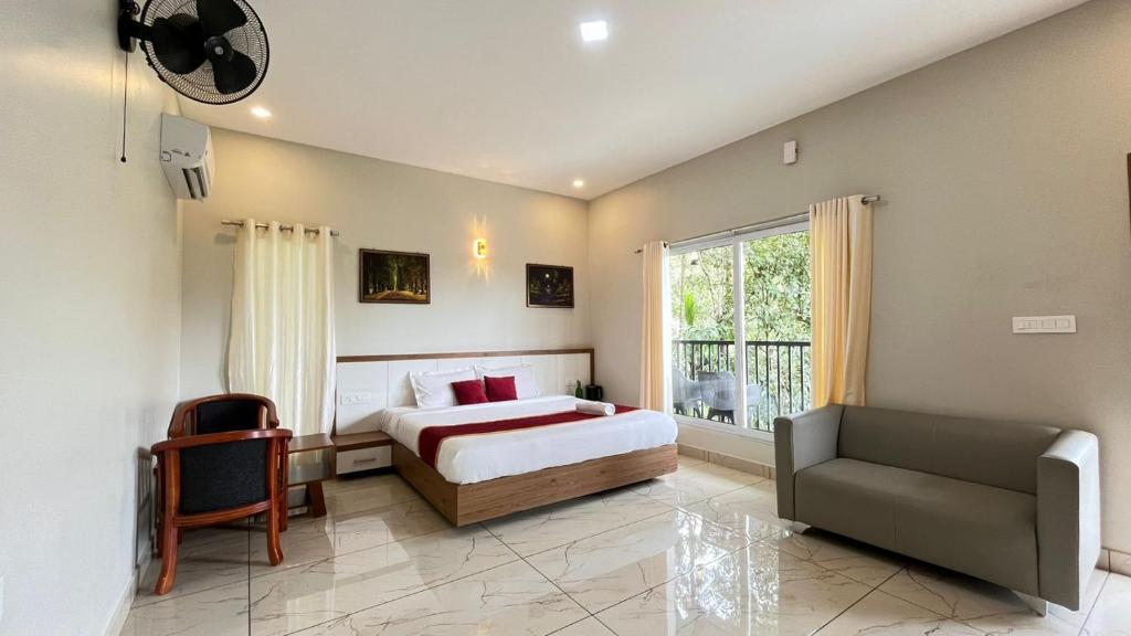- une chambre avec un lit, une chaise et une fenêtre dans l'établissement Mountain Vibes Resort Wayanad, à Wayanad