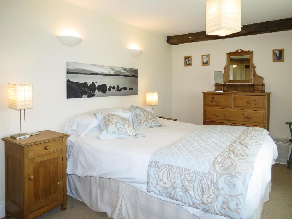 a bedroom with a white bed and a dresser at 3 Hazlewood in Aldringham