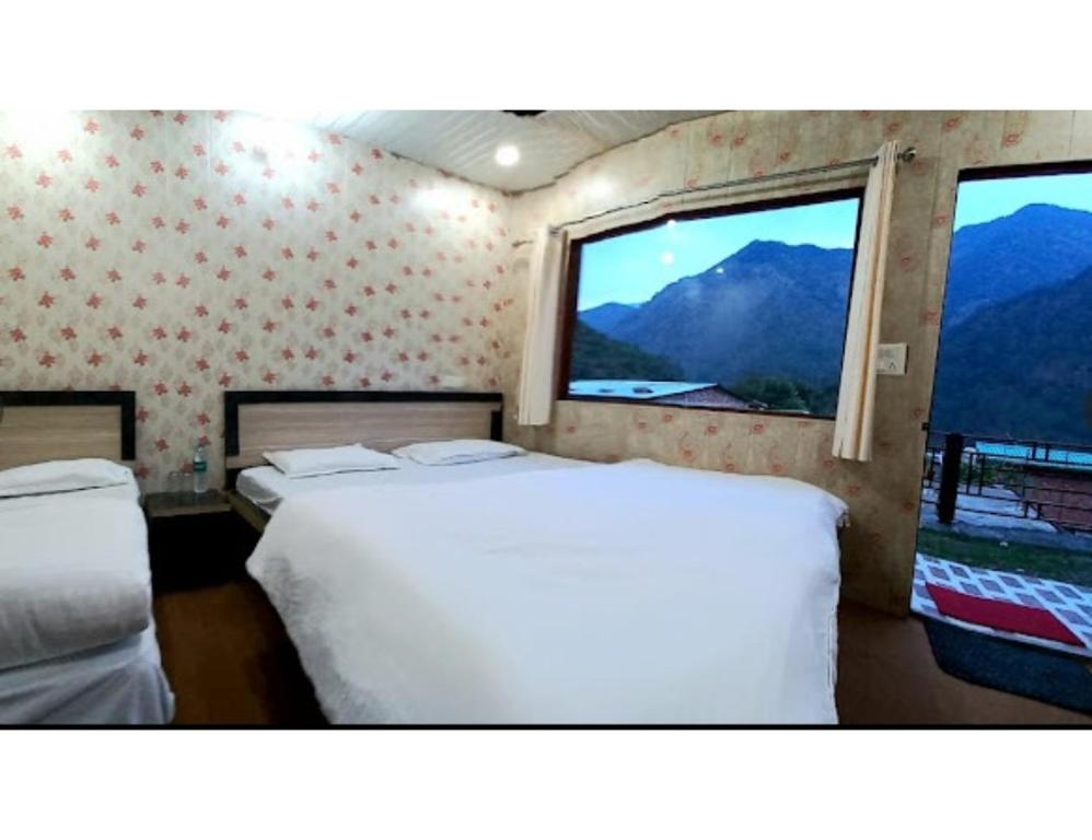 Natraj Heli Resort, Sersi في Phata: غرفة نوم بسريرين ونافذة بها جبال