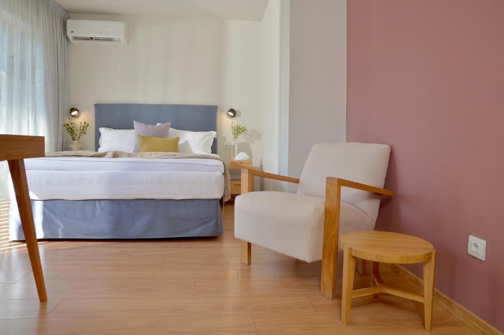 a bedroom with a bed and a chair at Mirivili Rooms & Suites in Athens