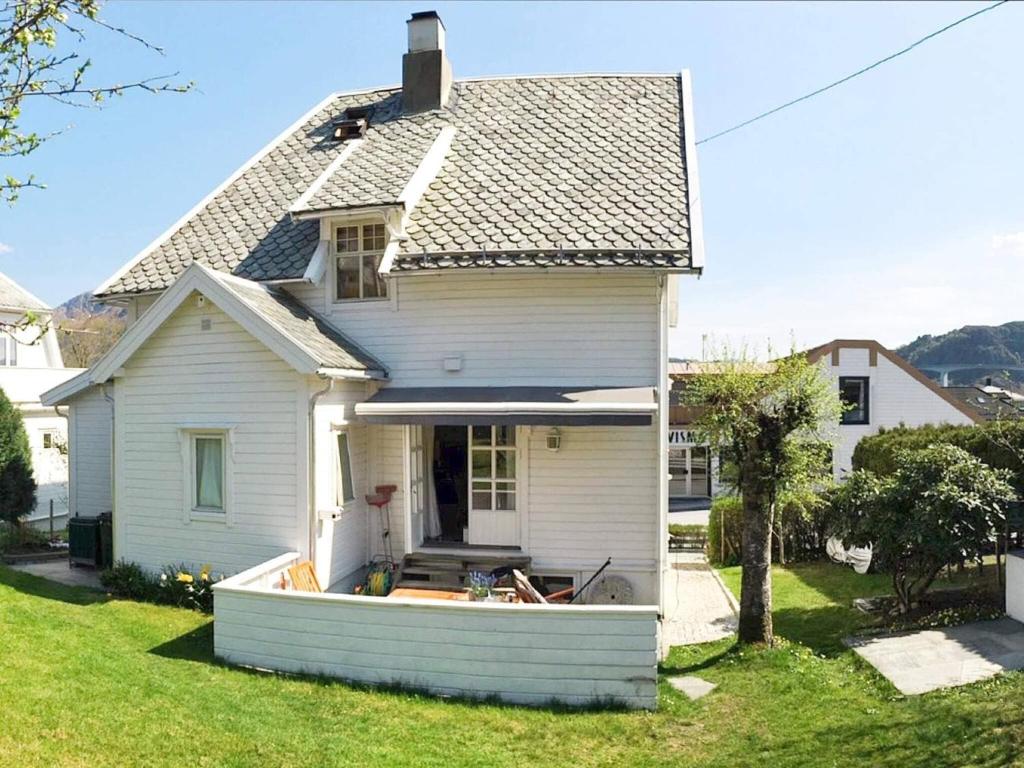 a white house with a porch and a yard at 8 person holiday home in MÅLØY-By Traum in Måløy