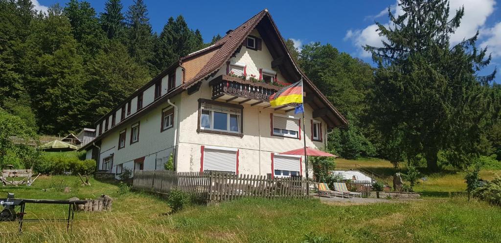 a house with a flag on the front of it at Ferienhof Ziegler - Studio Fingerhut in Baiersbronn