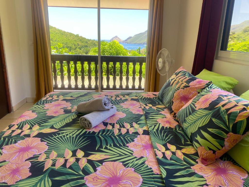 Ce lit se trouve dans une chambre avec vue sur une fenêtre. dans l'établissement HEIIKIANI Sweet Home, à Nuku Hiva