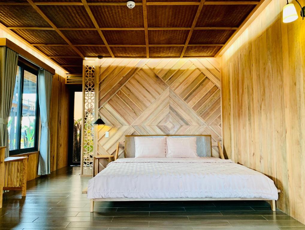 Cama en habitación con pared de madera en Cái Gùi Tà Đùng, en Biđong
