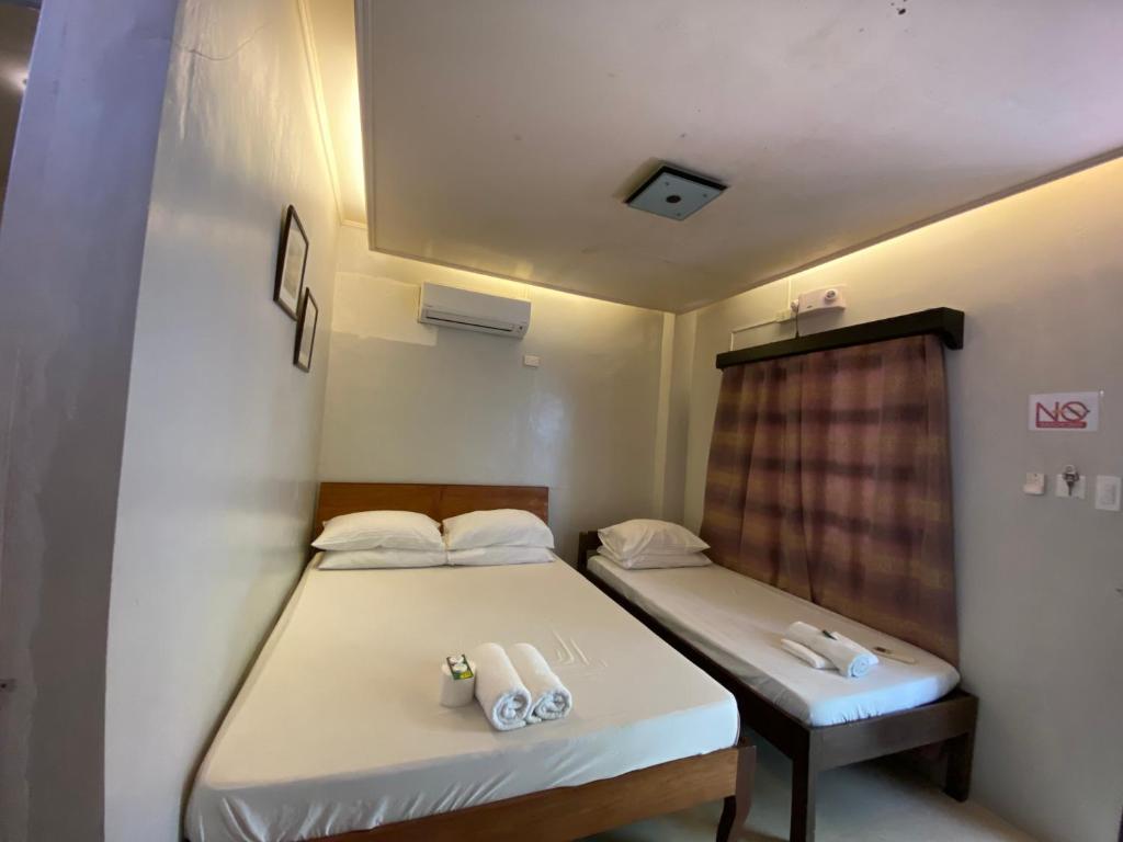 a room with two beds and a window at Giecel Pension in El Nido