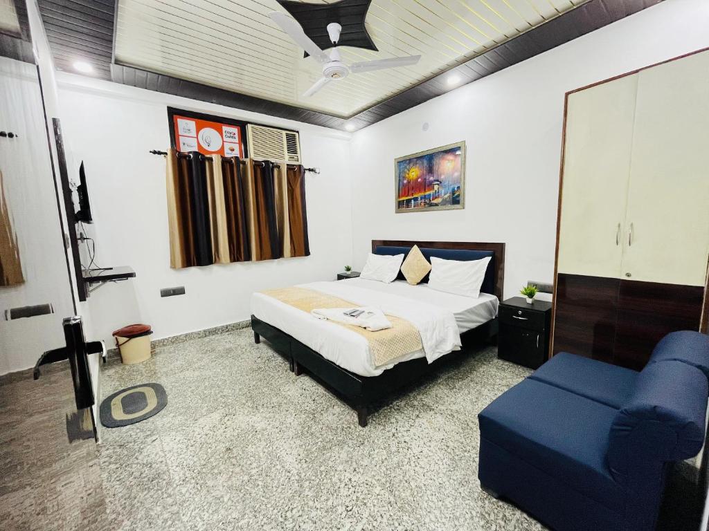 1 dormitorio con 1 cama y 1 silla azul en Roomshala 166 Hotel You Own - Vikas Puri en Nueva Delhi