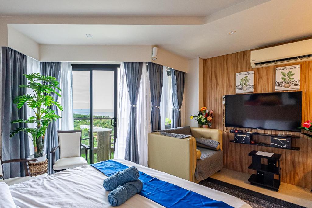 a hotel room with a bed and a flat screen tv at 14DC Tambuli Seaside Living in Lapu Lapu City