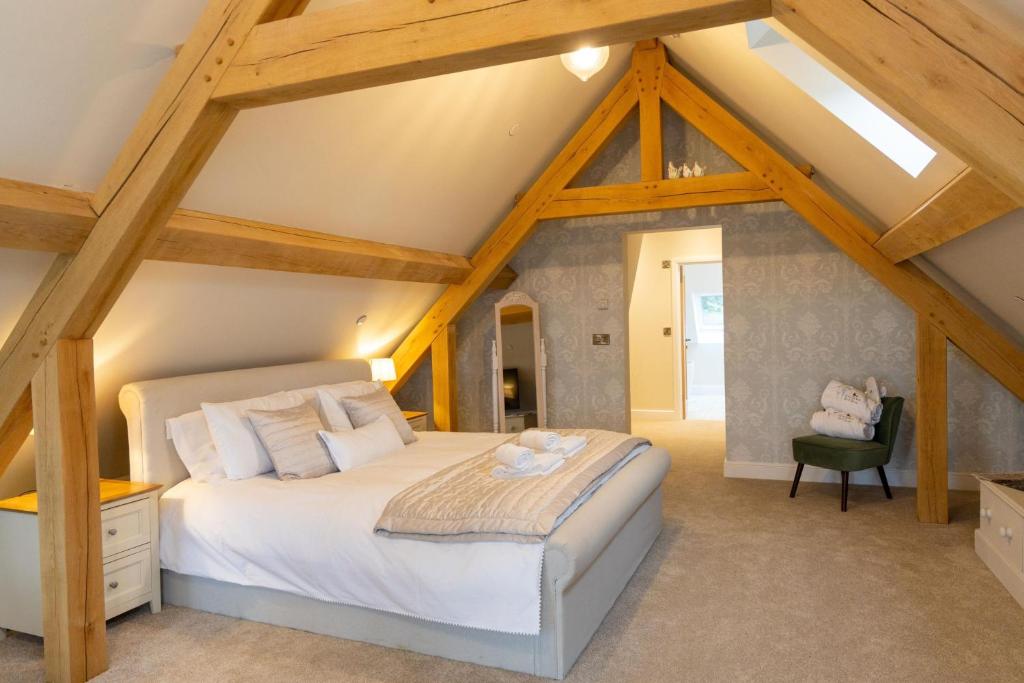 sypialnia z dużym białym łóżkiem na poddaszu w obiekcie Plas Robin w mieście Llandyssil