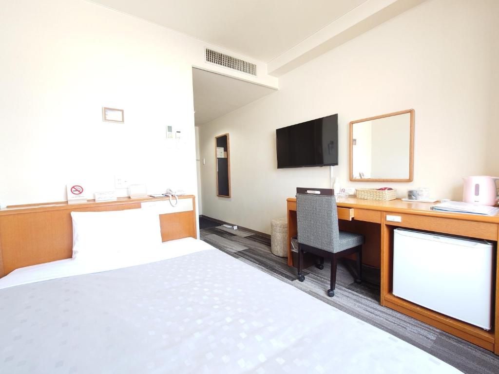 Pokój hotelowy z łóżkiem i biurkiem z telewizorem w obiekcie SAIDAIJI GRAND HOTEL - Vacation STAY 92835 w mieście Okayama