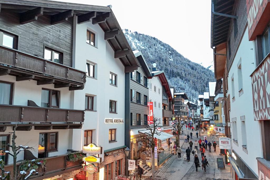 Eine Gruppe von Menschen, die in einer Stadt eine Straße entlang laufen in der Unterkunft Hotel Kristall in Sankt Anton am Arlberg