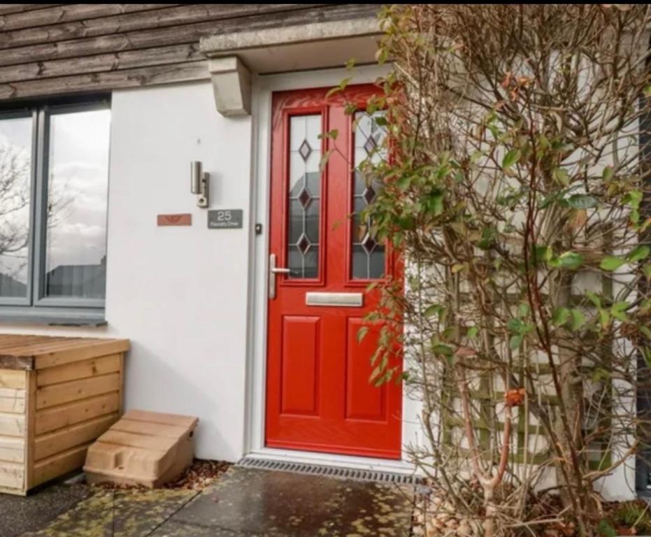 a red door on a white house at Captains Quarters in Charlestown