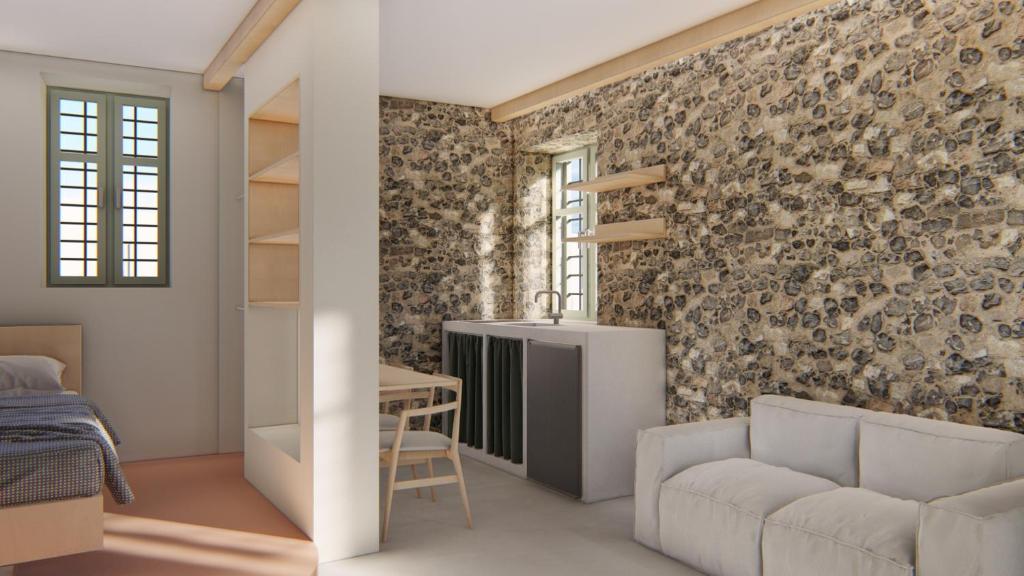 Habitación con pared de ladrillo, sofá y mesa. en Capella Poulia's Home, Skiathos, en Skiathos