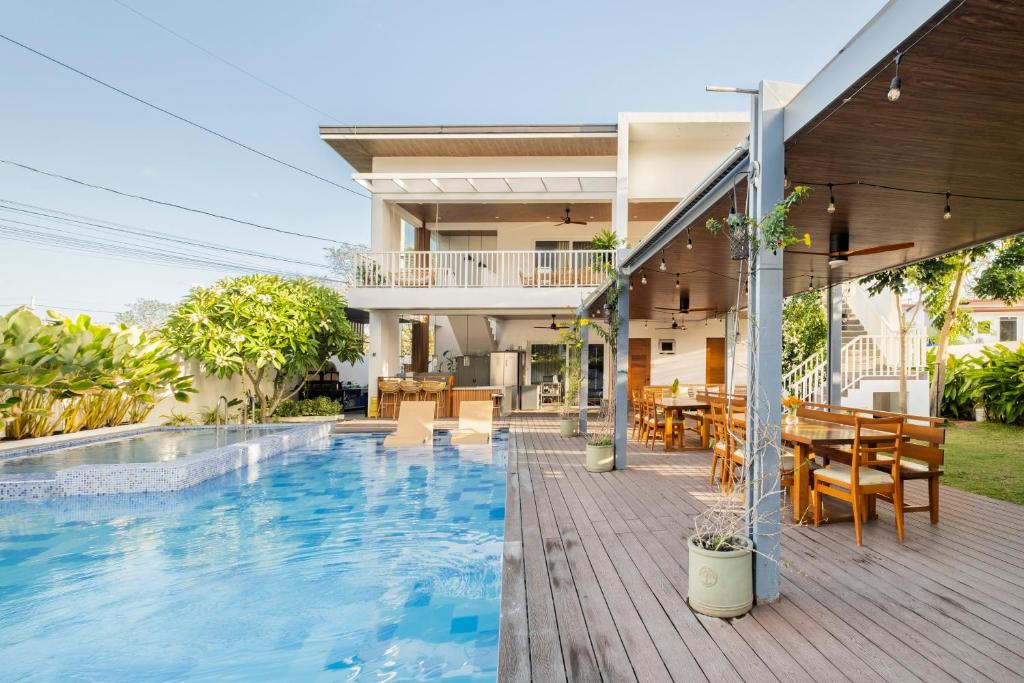 une maison avec une piscine et un coin repas dans l'établissement Tirta Spring Villa (5br) Vacation House, à Los Baños