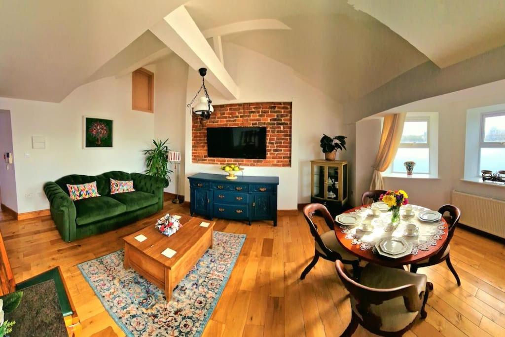 ein Wohnzimmer mit einem grünen Sofa und einem Tisch in der Unterkunft The Three Musketeers, Aramis in Eastbourne