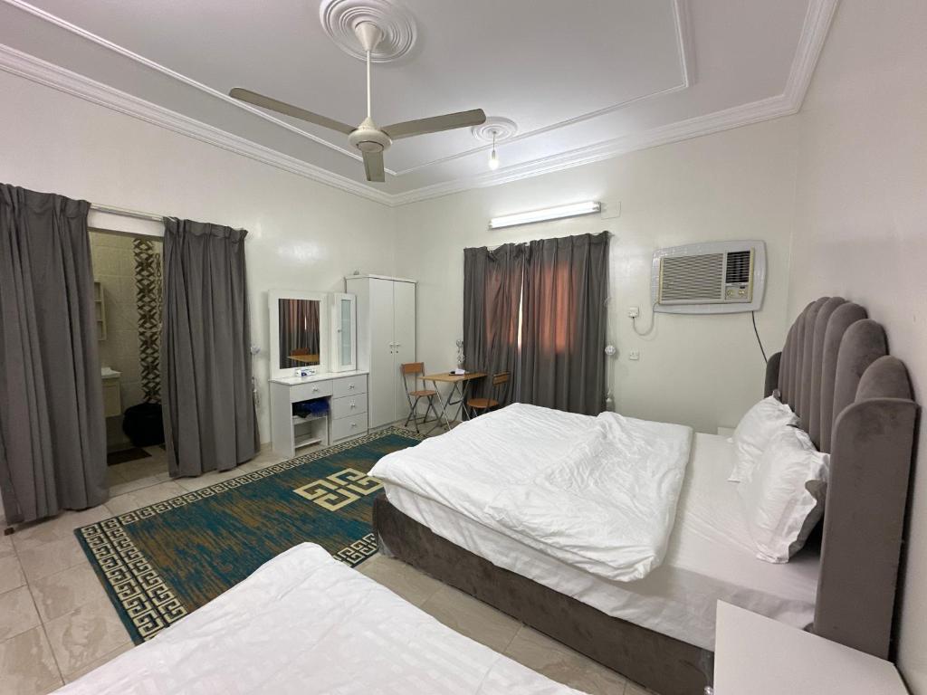 a bedroom with a bed and a desk in it at Al-Olaya Apartment in Umm Lujj