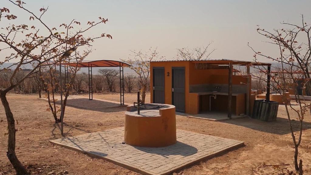 a small building in the middle of a field at Opuwo Country Lodge Campsite in Opuwo