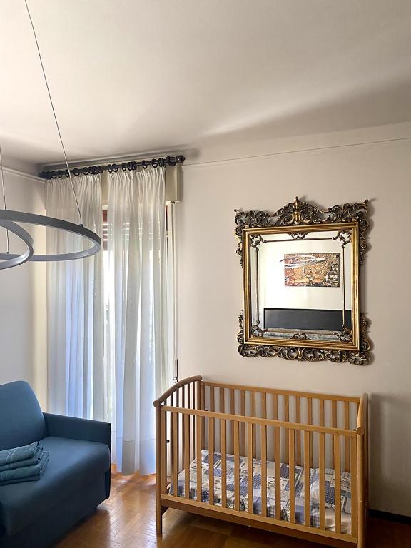 - une chambre bébé avec un lit bébé et un miroir dans l'établissement Villa Senagra Holidays Lake Como, à Menaggio