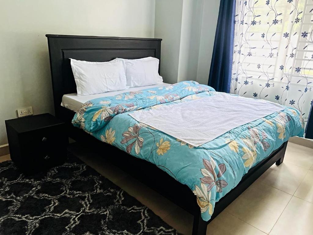 a bedroom with a bed with a colorful comforter at Oaklands Apartments in Morogoro