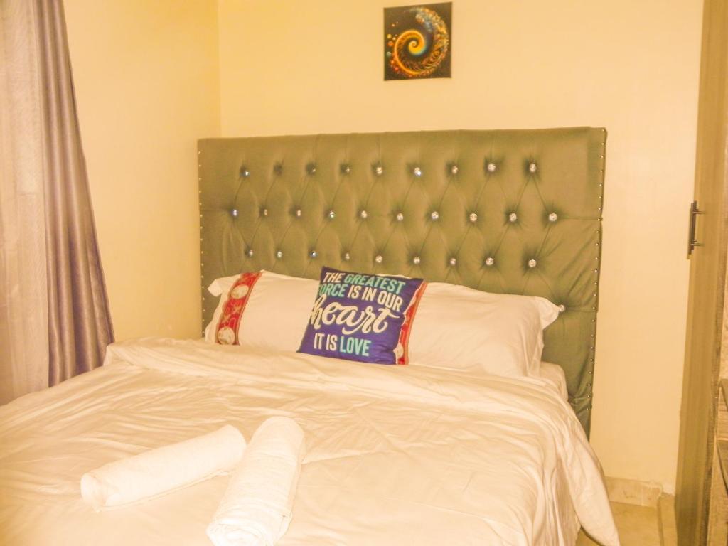 a bed with a pillow on top of it at Jack Haven Bnb in Kitengela 