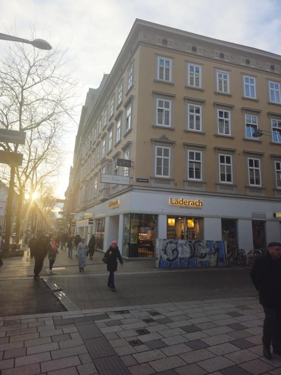 eine Gruppe von Menschen, die vor einem Gebäude spazieren in der Unterkunft Urban Boutique Hotel in Wien