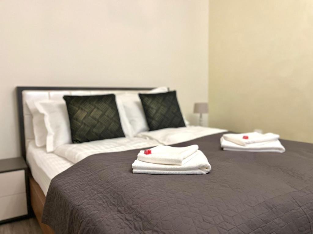 a bed with two white towels on top of it at Helia Apartment in Galaţi