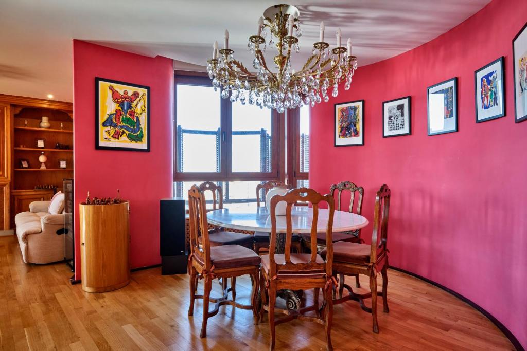 マドリードにあるApartamento de lujoの赤い壁のダイニングルーム(テーブル、椅子付)