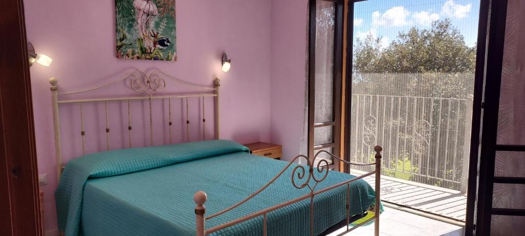 a bedroom with a bed and a balcony at LA ROSA DEI VENTI ACCOMADACION in Chia