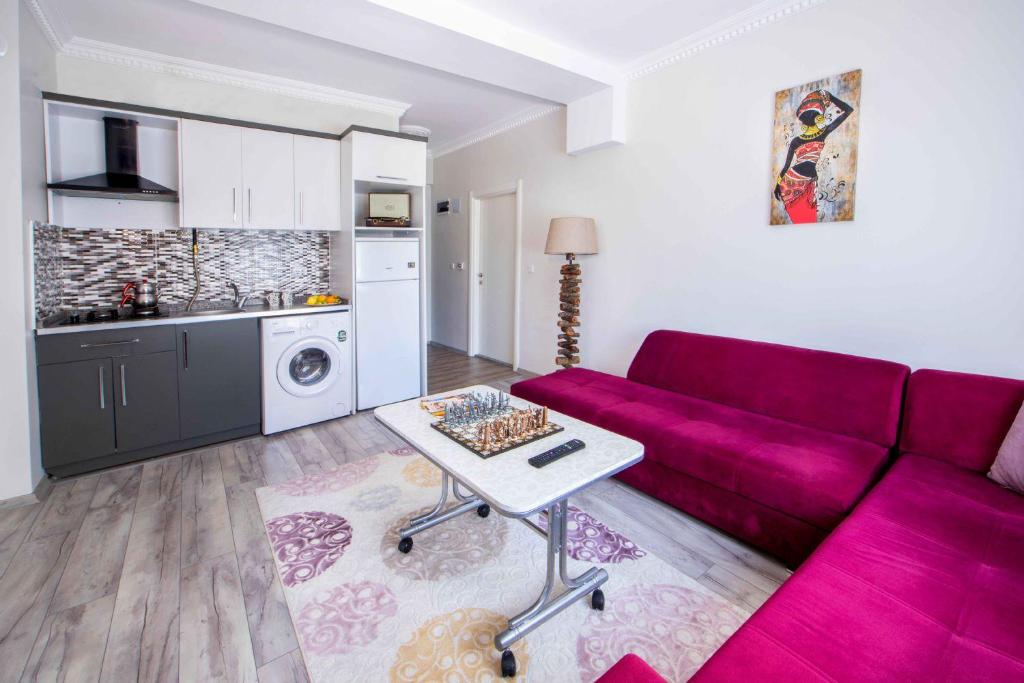 a living room with a purple couch and a kitchen at seyir royal in Kayseri