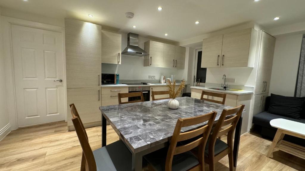 a kitchen and dining room with a table and chairs at Modern Flat 5 Min From Wembley Stadium 30 Min From London in London