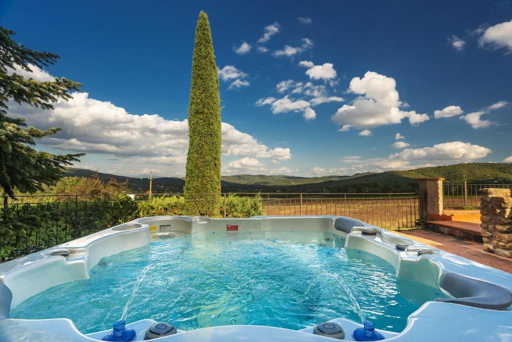 a hot tub in a backyard with a tree at Relais La Martina in Pietraviva