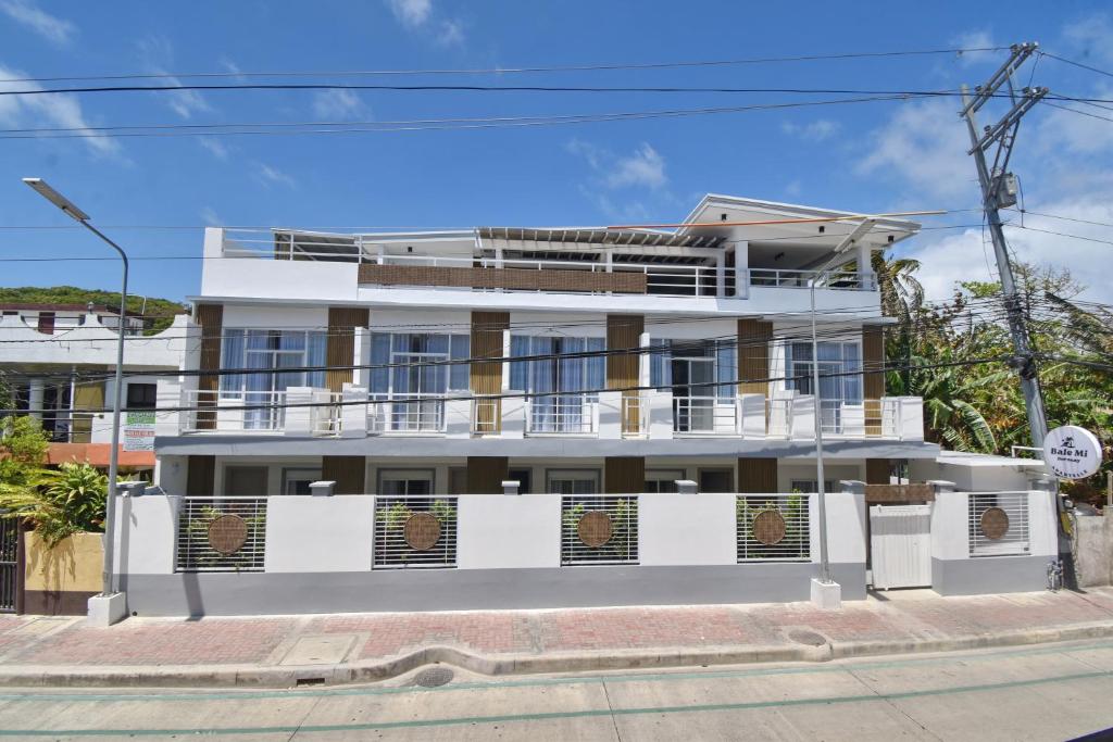 a white building with a balcony on a street at Bale Mi Boracay in Boracay