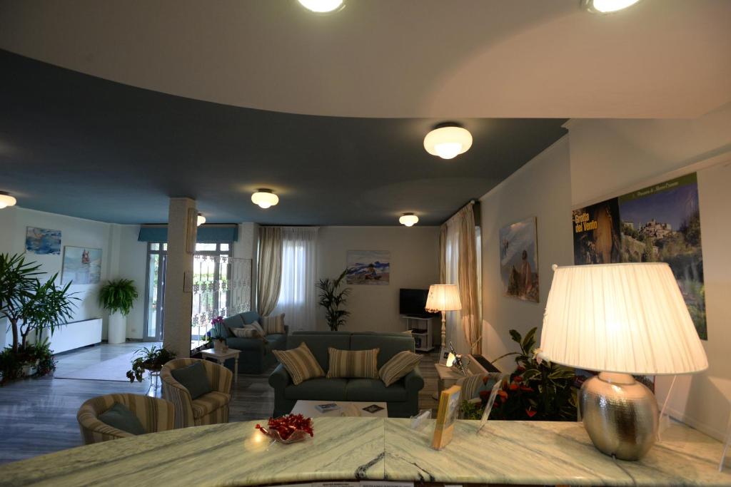 a living room with a couch and a table with a lamp at Hotel Giulio Cesare in Cinquale