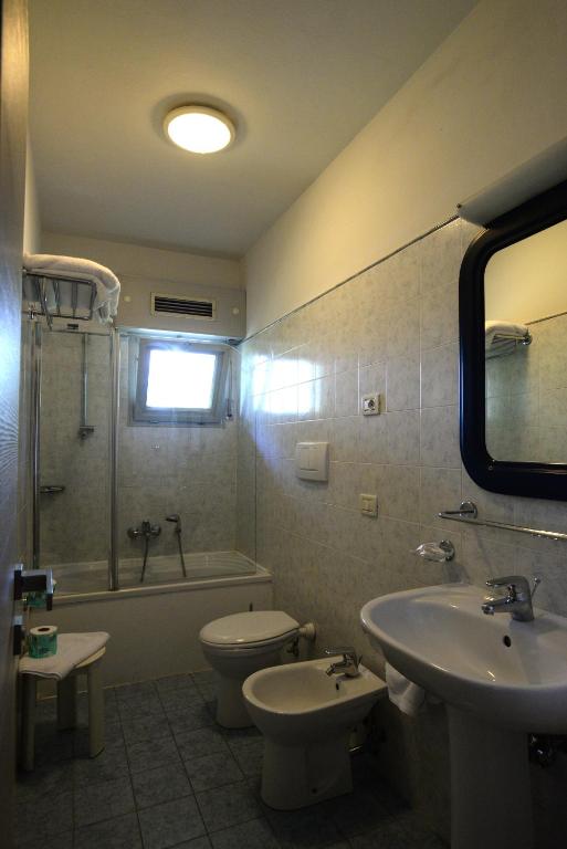 a bathroom with a sink and a toilet and a tub at Hotel Giulio Cesare in Cinquale