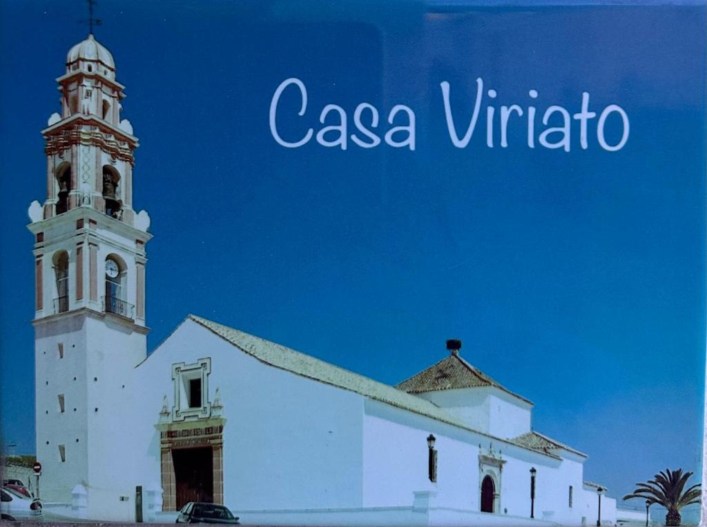 uma igreja branca com uma torre de relógio em cima em CASA VIRIATO em Ayamonte