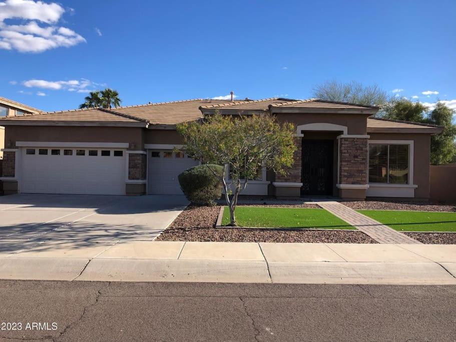 a house with a driveway and a garage at Cozy Latitude home with pool in Goodyear