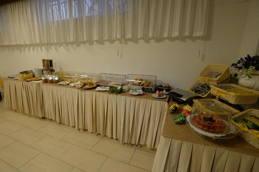 a row of buffet tables with food on them at Hotel Giulio Cesare in Cinquale