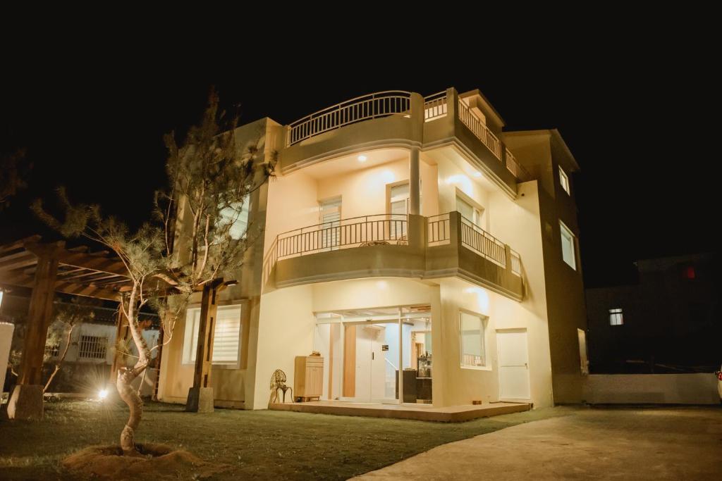 un gran edificio blanco con un árbol delante en Deer Tea B&B en Longtian